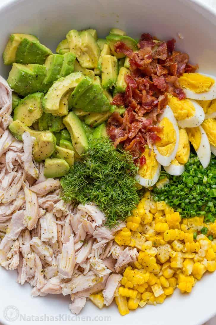 Fresh ingredients for a nutritious lunch bowl including protein, healthy fats, and vegetables